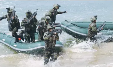  ??  ?? SPECIAL OPERATION forces of the Korean People’s Army, guided by North Korean leader Kim Jong Un, take part in a target-striking contest to occupy islands in this undated picture provided by KCNA in Pyongyang on Friday. (Reuters)