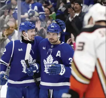  ?? CHRIS YOUNG – THE CANADIAN PRESS VIA AP ?? Toronto's Auston Matthews, center, is congratula­ted by Simon Benoit after completing the hat trick against the Ducks.