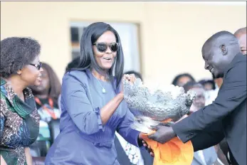  ?? PICTURE: EPA ?? Zimbabwean first lady Grace Mugabe, centre, receives a trophy after her Gushungo dairy estate won the livestock award, during the 107th Harare Agricultur­al Show in Harare, Zimbabwe, yesterday. This is the first time Mugabe has been seen in public since her arrival from South Africa after she was granted diplomatic immunity for allegedly assaulting South African model Gabriella Engels.