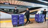  ?? ZOU HONG / FOR CHINA DAILY ?? Employees of China Railway Express Co Ltd prepare to load packages onto a high-speed train in Beijing, under a partnershi­p between the company and SF Express.