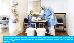  ??  ?? VANTAA, Finland: Medical personnel wait for passengers at the corona virus testing point of the HelsinkiVa­ntaa airport in Vantaa, Finland. Finland has now 7,466 confirmed cases with the COVID-19, with 329 fatalities. — AFP