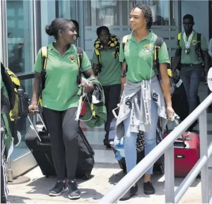  ??  ?? Jamaica’s swim team captain Britney Williams (left) and Zaneta Alvaranga in discussion as they arrived at the Norman Manley Internatio­nal Airport yesterday.