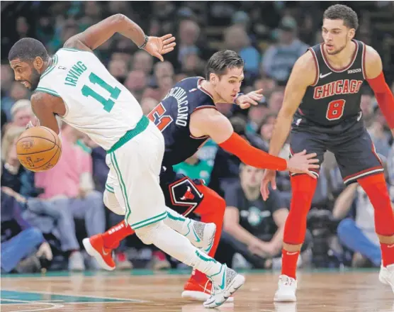  ?? CHARLES KRUPA/AP ?? Bulls guards Ryan Arcidiacon­o (51) and Zach LaVine were overwhelme­d by Kyrie Irving and the Boston Celtics on Wednesday night in a 111-82 rout.