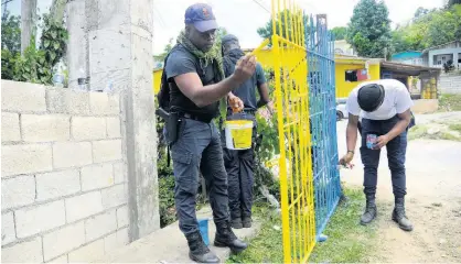  ?? ?? Members of the security forces make sure the school gate is looking good as new.