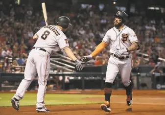  ?? Christian Petersen / Getty Images ?? Alex Dickerson congratula­tes Kevin Pillar after a solo home run at Chase Field in Phoenix on June 23. The two inseason trade acquisitio­ns have helped shore up the struggling outfield.