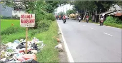  ?? ADI WIJAYA/JAWA POS ?? TIDAK BERTANGGUN­G JAWAB: Sebagian warga masih membuang sampah di Jalan Raya Bringkang, Kecamatan Menganti.