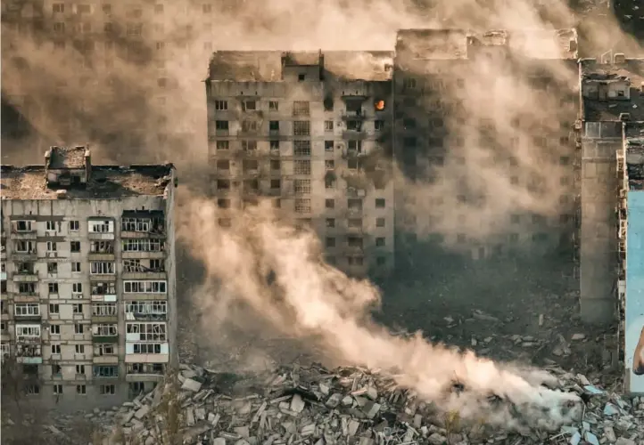  ?? AP / NTB ?? Røyk stiger opp fra de utbombede ruinene i Bakhmut i Donetsk-regionen i april i fjor, et av områdene som har opplevd de hardeste kampene siden den russiske invasjonen for to år siden.