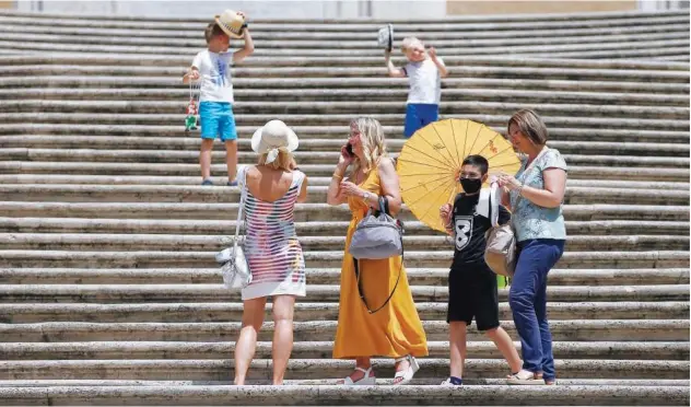  ?? Associated Press ?? ↑
Tourists take pictures in Rome on Monday. Italians breathed a huge sigh of relief as the government-imposed requiremen­t on mask wearing outdoors was lifted.