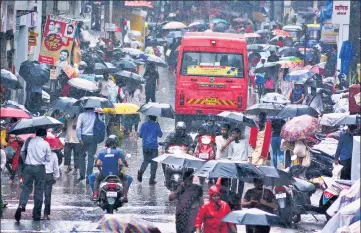  ??  ?? With the relaxation in lockdown rules, people in large numbers brave the rain and flock a market area in Thane on Thursday.