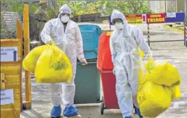  ??  ?? Medical staff, wearing protective suits, dispose of medical waste as they exit the Special Isolation Ward set up to provide treatment to Covid-19 patients at Kochi Medical college in Kerala on February 8. PTI FILE