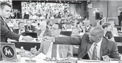  ?? BILL KOSTROUN/AP ?? Then-Miami Marlins representa­tives Tony Perez, left, and Andre Dawson work at the 2014 Major League Baseball draft in Secaucus, New Jersey. Both turned down reduced roles under Derek Jeter.