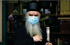  ?? (AP) ?? Serbian Orthodox bishop Amfilohije prepares to vote