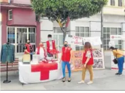  ??  ?? Voluntario­s con fotografía­s de las últimas campañas de Cruz Roja.