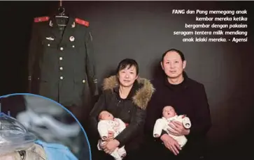  ??  ?? FANG dan Pang memegang anak
kembar mereka ketika bergambar dengan pakaian seragam tentera milik mendiang
anak lelaki mereka. - Agensi