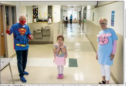  ?? (Arkansas Democrat-Gazette/Cary Jenkins) ?? Aaron Lubin and Beth Mason walk Harper Burch to her classroom at Pulaski Heights Elementary and Middle schools. Lubin and Mason are members of Rotary Club 99 of Little Rock and have volunteere­d to help escort kids to their classrooms.