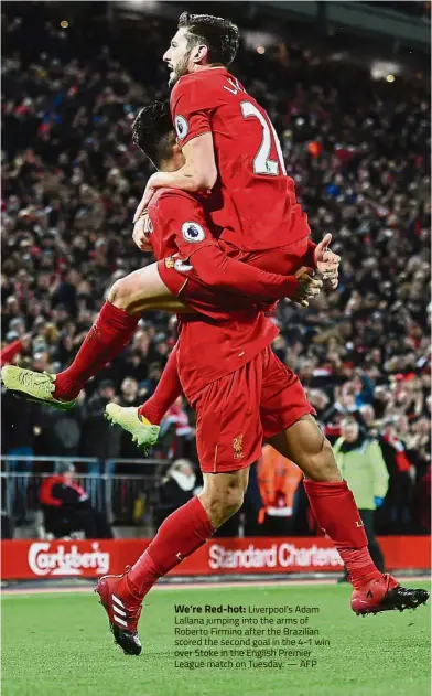  ??  ?? We’re Red-hot: Liverpool’s Adam Lallana jumping into the arms of Roberto Firmino after the Brazilian scored the second goal in the 4-1 win over Stoke in the English Premier League match on Tuesday. — AFP