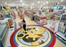  ?? DANIEL HULSHIZER — THE ASSOCIATED PRESS FILE ?? FILE- In this file photo, a woman pushes a shopping cart over a graphic of Toys R Us mascot Geoffrey the giraffe at the Toys R Us store in Raritan, N.J.