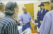  ??  ?? Mark Snyder, left, and Bob Belli, both with Shasta, a metal conditioni­ng service in Aliquippa, speak to job candidates at a job fair Thursday at the Salvation Army in Aliquippa.