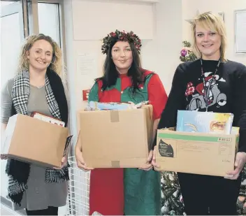 ??  ?? Annmarie Sirs (middle) and Kirsty Hewitt (right), both from East Durham Homes, donate food to Lindsey Wood (left), of East Durham Trusts, for the FEED project.