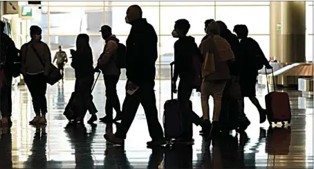  ?? RICK BOWMER / AP / FILE ?? Air travelers line up to go through a a security checkpoint on Nov. 25 at Salt Lake City Internatio­nal Airport in Utah. Data from roadways and airports shows millions could not resist the urge to gather on Thanksgivi­ng, even during a pandemic.