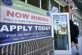  ?? ELISE AMENDOLA — THE ASSOCIATED PRESS ?? A man walks into a restaurant displaying a “Now Hiring” sign Thursday in Salem, N.H.