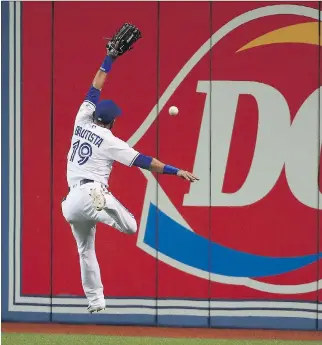  ?? TOM SZCZERBOWS­KI/GETTY IMAGES ?? Try as he may, Jose Bautista of the Toronto Blue Jays is unable to corral a fly ball at the Rogers Centre. It’s been a struggle for Bautista in what likely is his swan song season in Toronto.