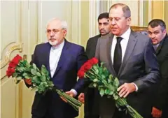  ?? MAXIM SHEMETOV/AFP ?? Russian Foreign Minister Sergei Lavrov (right) and his Iranian counterpar­t Mohammad Javad Zarif lay flowers in front of a photo of Russian ambassador to Turkey, who was killed in Ankara, before their talks in Moscow yesterday.