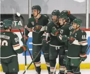  ?? Stacy Bengs / Associated Press ?? Minnesota’s Kirill Kaprizov is surrounded by teammates after scoring a goal in overtime to win.