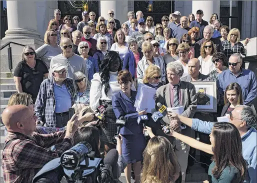  ?? Will Waldron / Times Union ?? Attorney Victoria Esposito, advocacy coordinato­r for the Legal Aid Society of Northeaste­rn New York, center, speaks to the media after filing a lawsuit on behalf of St. Clare’s pensioners against the Roman Catholic Diocese of Albany on Tuesday at the Schenectad­y County Judicial Building in Schenectad­y. She was joined by St. Clare’s pensioners and family members.