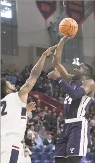 ?? Steve Musco / Yale Athletics ?? Yale’s Miye Oni gets his jumper off over the outstretch­ed arm of Penn’s Antonio Woods during the second half of Penn’s 80-57 victory at The Palestra in Philadelph­ia, Pa.