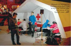  ?? — AFP ?? Migrants are attended by members of the Red Cross at Algeciras’ harbour after their rescue off the Spanish coast.