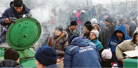  ?? Foto: Alexej Filippow, afp ?? Endlich eine warme Mahlzeit: Am Sonntag wurden Bewohner der umkämpften Stadt Awdijiwka aus der Gulaschkan­one versorgt.