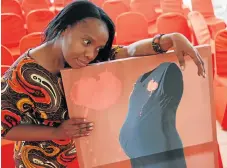  ?? Picture: JACKIE CLAUSEN ?? MATERIAL WITNESS: Ntozanele Khanyi with a photograph of a dress which she has used to portray her tale of abuse. Khanyi, who is in a shelter for abused women, has received training in design and sewing and is using her skills to support herself