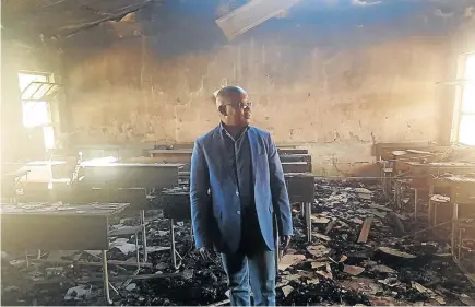  ?? / MANDLA KHOZA ?? Mpumalanga MEC for education Sibusiso Malaza inspects Siyathokoz­a Senior Secondary School in Siyabuswa, which was allegedly torched by people unhappy with by-election results.