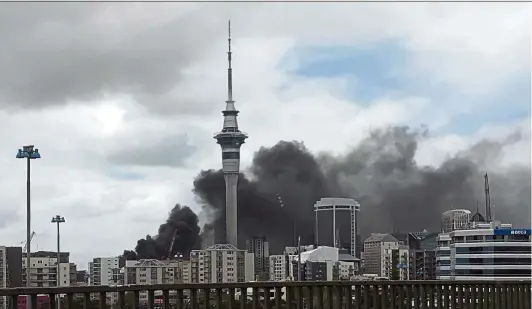  ?? — AFP ?? City in danger: A huge fire at a constructi­on site sent clouds of acrid black smoke billowing over the city of Auckland forcing large parts of the downtown area to be cordoned off as firefighte­rs battled the blaze near the SkyCity convention centre.