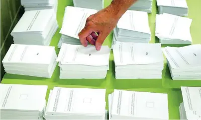  ?? EFE ?? Un hombre coge una papeleta para votar el referéndum del Estatut en 2006