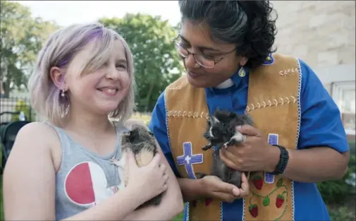  ?? ADAM GAGNON, SPECIAL TO THE RECORD ?? Kari Stiller, 11, gets her two guinea pigs, Onyx and Bella, blessed by Pastor Janaki Bandara of St. Peter’s Evangelica­l Lutheran Church on Sunday afternoon.