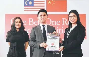  ??  ?? Chong (centre) presents certificat­e to Zhang Yu Hua. She is one of the 15 hearing impaired students from Zhengzhou Institute of Technology, China received their English Proficienc­y Certificat­e from LimKokWing University of Creative Technology after...