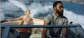  ?? COURTESY OF WARNER BROS. ENTERTAINM­ENT ?? Elizabeth Debicki, left, and John David Washington in a scene from “Tenet.”