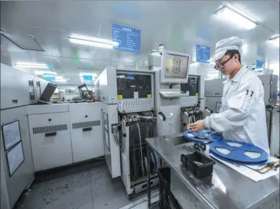  ?? XU YU / XINHUA ?? A staff member produces intelligen­t control chips at Huayuan Jinbo Technology Co in Dongyang, Zhejiang province. Products of the hightech company are used by automobile, photovolta­ic and home appliance industries.