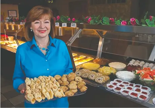  ?? ?? Angie Golom holds a tray of desserts at Warsaw Inn in Lynwood.