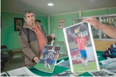  ?? — AFP ?? Technical staff of the Rodelino Roman club show pictures of Chilean star Arturo Vidal, at the club in Santiago in the neighbourh­ood where he grew up.