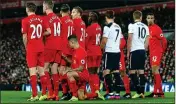  ??  ?? HOLE IN THE WALL: Coutinho has a peek past Henderson and Firmino and kneels to block should Spurs hit a low free-kick