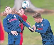  ??  ?? An Annfield player (red) rises to head between two Charlie Accies players during a DSA league clash.