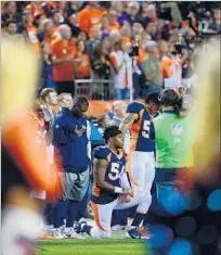  ?? Dustin Bradford Getty Images ?? SOME ANALYSTS have suggested that the NFL is facing a fan backlash over player protests. Above, a Denver Broncos player takes a knee during the national anthem Monday.