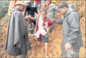  ?? JAYJAY LANDINGIN — THE ASSOCIATED PRESS ?? Rescuers assist a mother and her child as they evacuate to safer grounds following landslides that hit Itogon township, Benguet province in the Philippine­s on Sunday.