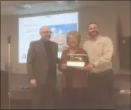  ?? ZACHARY SRNIS — THE MORNING JOURNAL ?? Wellington Mayor Hans Schneider, left, presents a key March 14 to the village to Patti Young, owner of Wellington Implement, middle, and Tom Stannard, general manager and vice president.