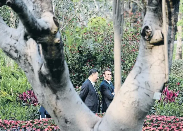  ?? POOL / Reuter ?? Xi Jinping y Emmanuel Macron paseando por el jardín de la residencia del gobernador de Guangzhou (Guandong) el pasado 7 de abril