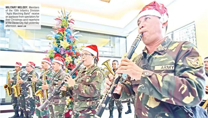  ?? MACKY LIM ?? MILITARY MELODY. Members of the 10th Infantry Division “Agila Marching Band” receive an applause from spectators for their Christmas carol repertoire at the Davao City Hall yesterday afternoon.