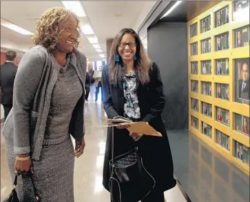  ?? Gina Ferazzi Los Angeles Times ?? IN 2010, then-new Assemblywo­man Holly Mitchell, left, and Sydney Kamlager smile after seeing Mitchell’s photo in the Capitol. Eight years later, Kamlager is the new assemblywo­man, and Mitchell is a state senator.